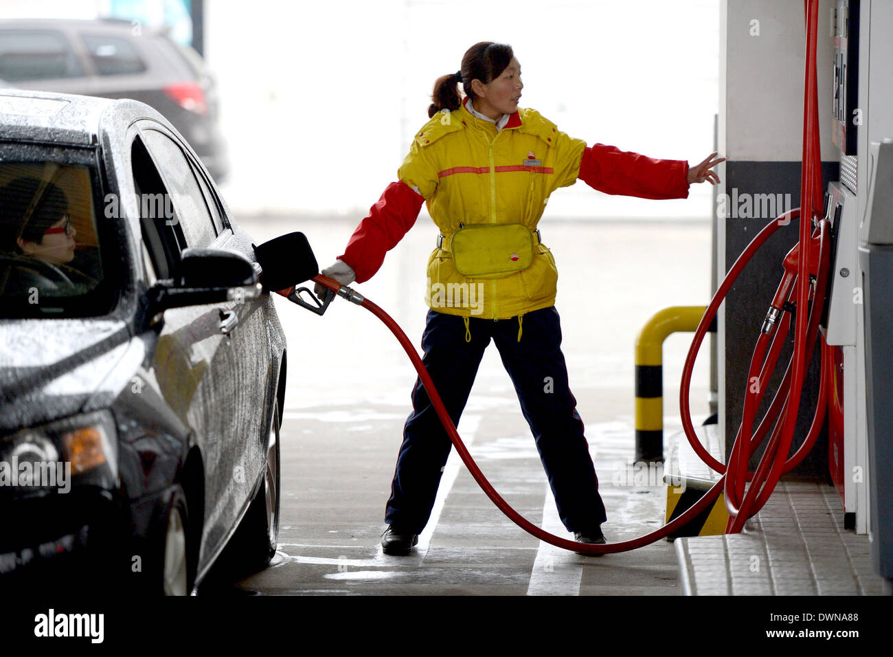 (140312) -- HEFEI, 12 mars 2014 (Xinhua) -- un membre du personnel remplit une voiture dans une station de Hefei, capitale de la Province d'Anhui en Chine orientale, le 12 mars 2014. La Commission nationale pour le développement et la réforme (NDRC), de Chine, de planificateur économique ne permet pas d'ajuster les prix du carburant de référence du pays, la limite supérieure pour les prix de détail de l'essence et diesel, le mercredi, selon les analystes de l'énergie. En vertu de l'actuel mécanisme de fixation des prix du carburant, a présenté le 26 mars 2013, le prix du carburant de référence sont indexés sur les prix du pétrole brut sur les marchés internationaux et ajusté tous les 10 jours de travail. Mais l'annonce Banque D'Images