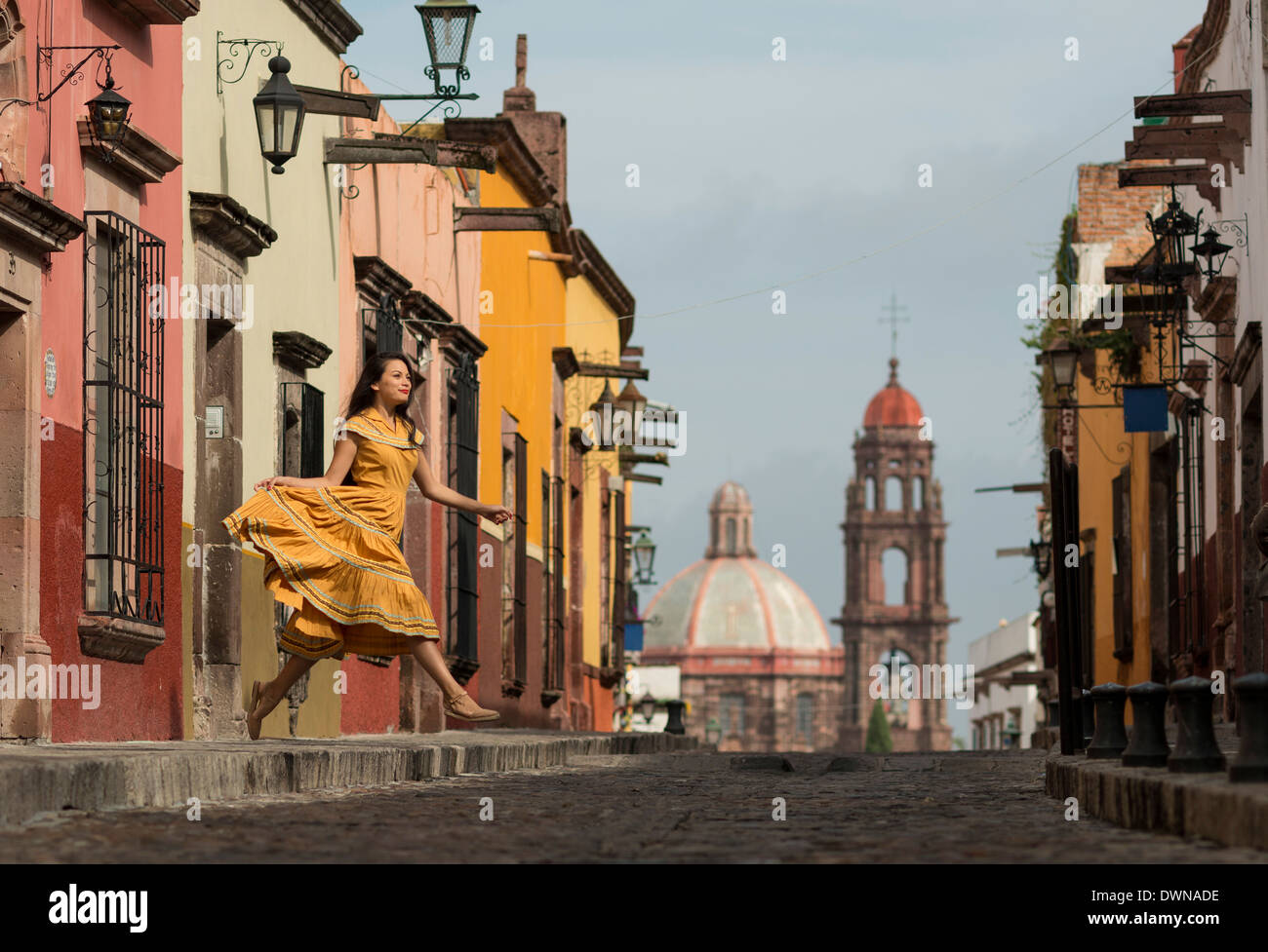 Jeune femme dansant vers le bas de la rue pavée (recreo), San Miguel de Allende, Guanajuato, Mexique, Amérique du Nord Banque D'Images