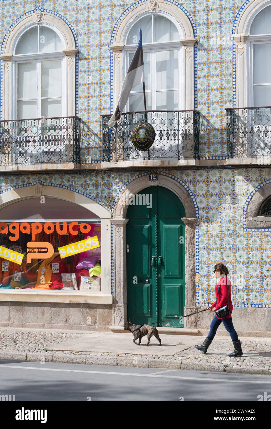 Woman walking dog passé le bâtiment du consulat d'Estonie à Tavira Algarve Portugal Europe Banque D'Images
