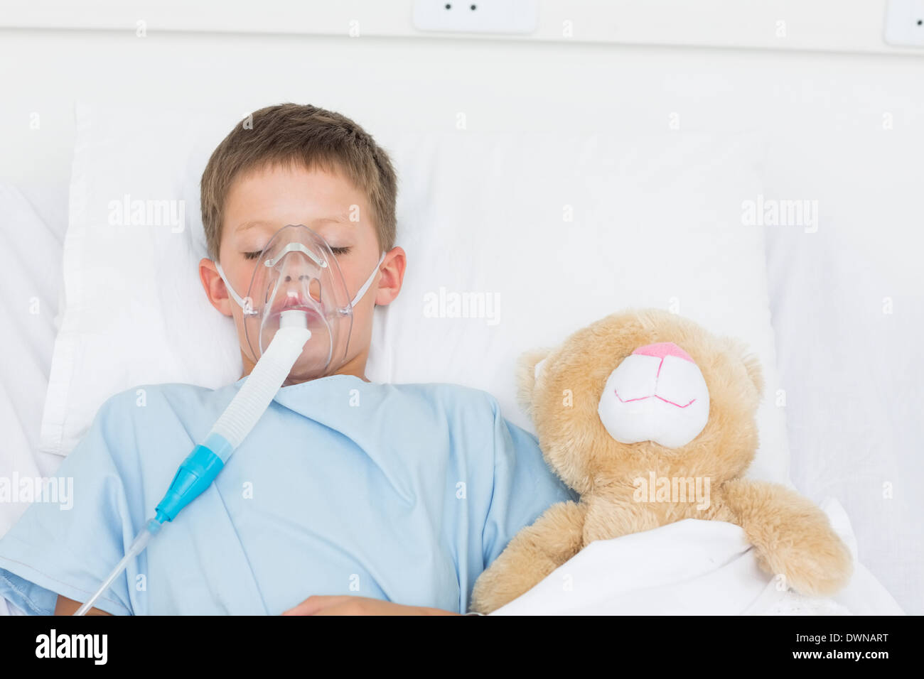 Boy wearing oxygen mask dormir à côté de Doudou Banque D'Images