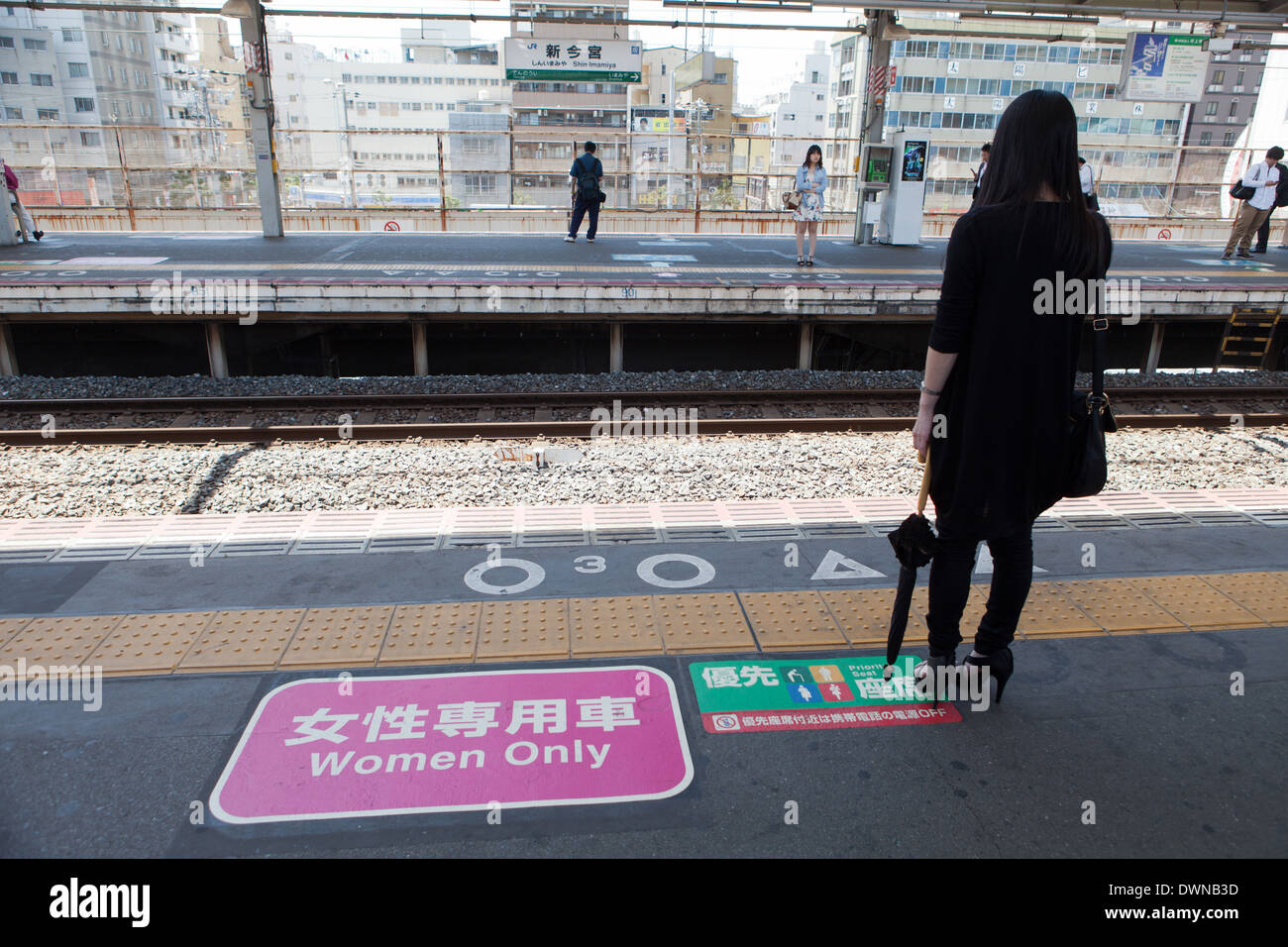 Le Japon, la station de chemin de fer. Une femme attend le train pour femmes seulement à bord d'un véhicule. Banque D'Images