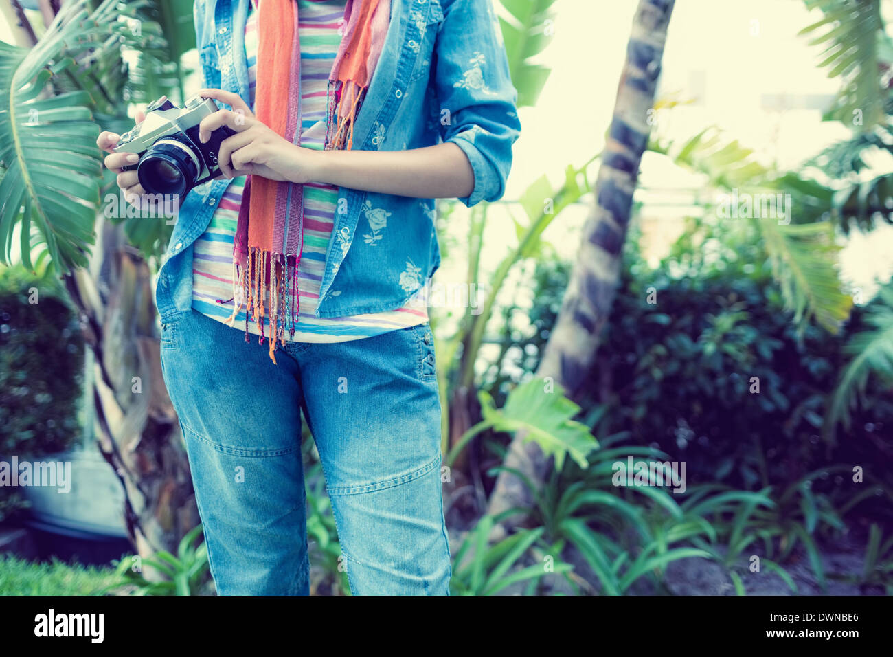 Woman wearing denim holding camera extérieur Banque D'Images