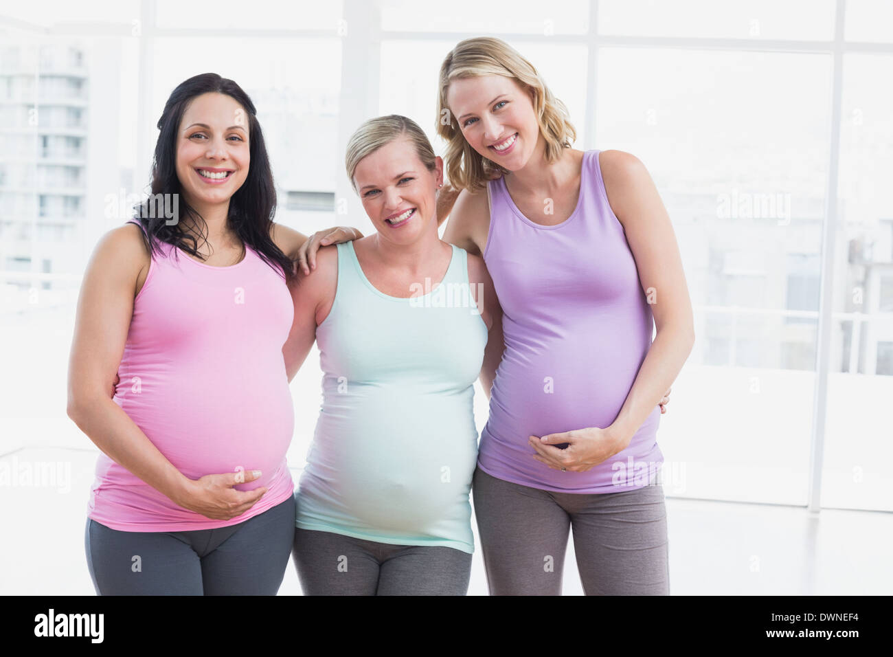 Les femmes enceintes standing smiling at camera Banque D'Images