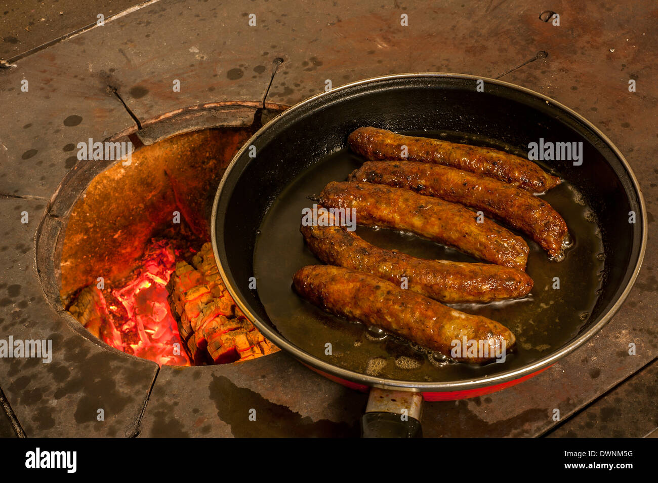 Les saucisses à la poêle dans une casserole sur un vieux poêle à bois, Middle Franconia, Bavaria, Germany. Banque D'Images