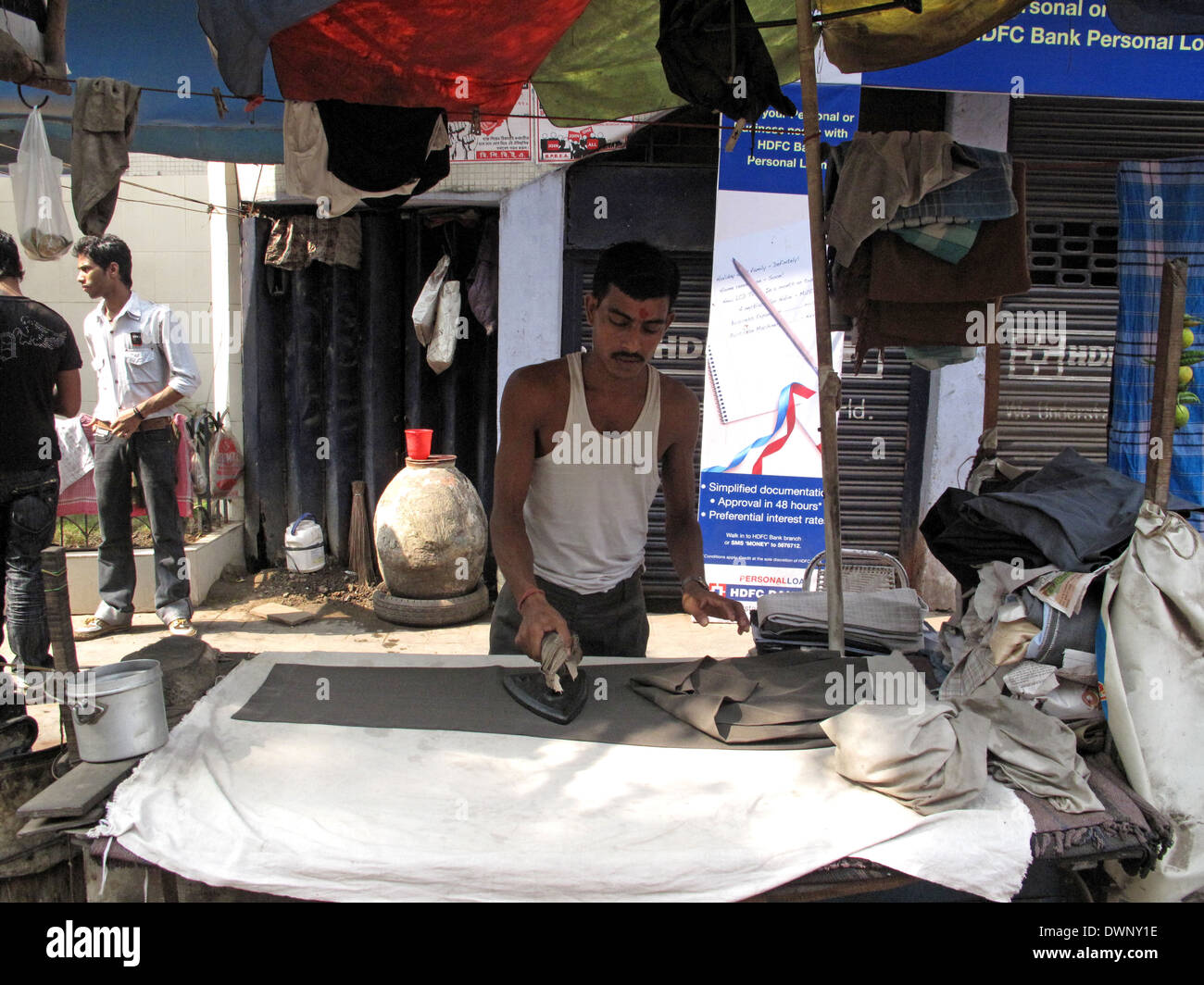 Rues de Calcutta. Vêtements Homme pantalon à l'aide d'un fer chauffé au charbon de bois traditionnel, le 25 janvier 2009. Banque D'Images
