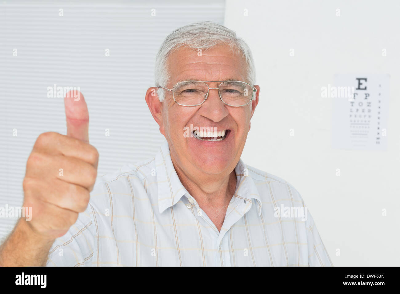 Smiling senior man gesturing Thumbs up avec l'œil en arrière-plan Banque D'Images