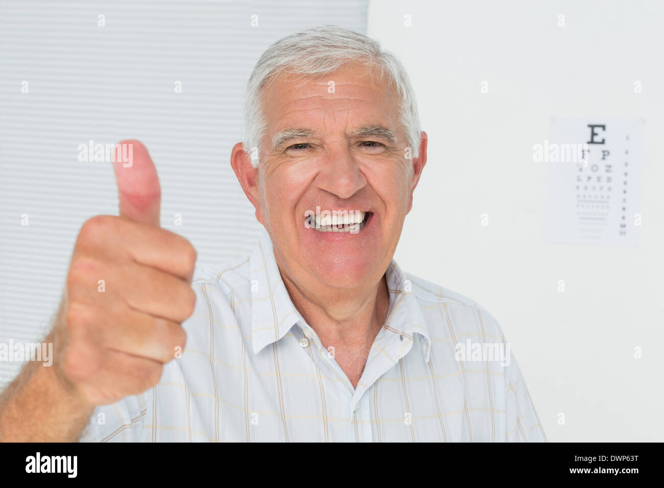 Smiling senior man gesturing Thumbs up avec l'œil en arrière-plan Banque D'Images
