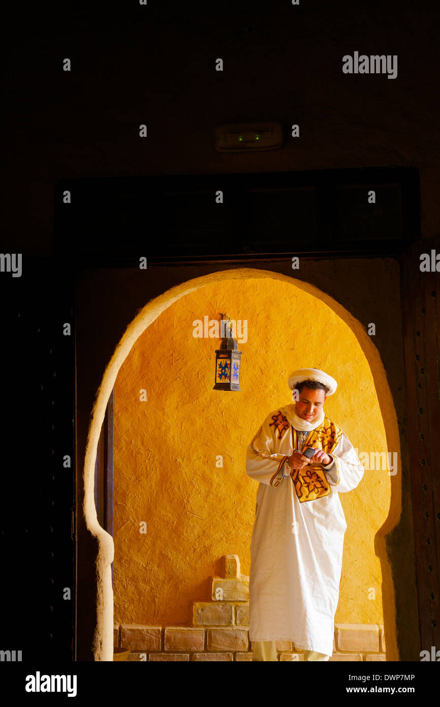 L'homme en costume berbère berbère avec téléphone mobile, Merzouga, Maroc, Afrique du Nord Banque D'Images