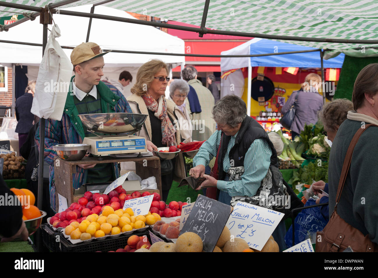 Le paiement du client pour des achats sur l'étal de fruits et légumes. Banque D'Images