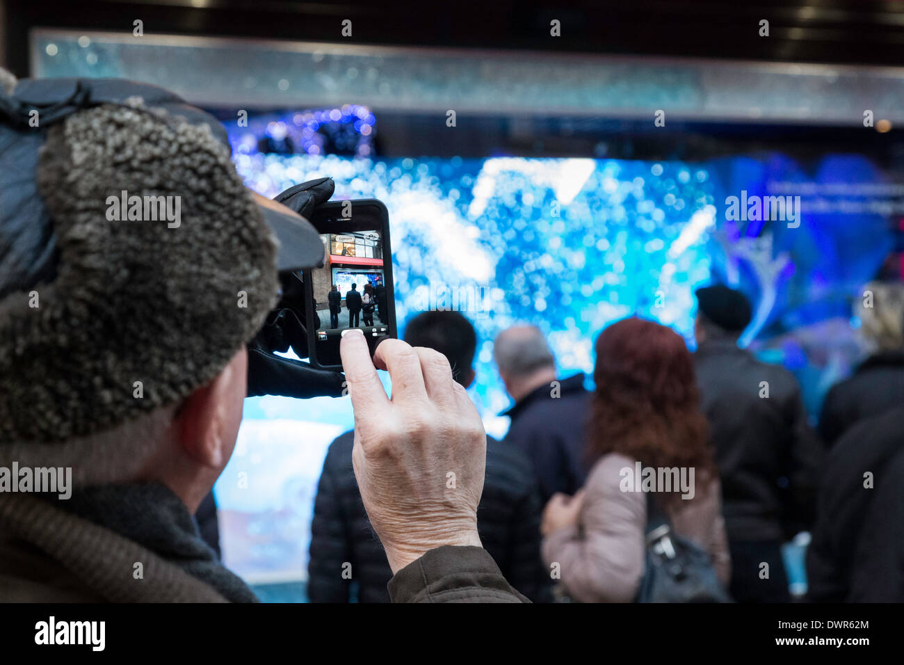 L'homme à l'aide d'un téléphone cellulaire de Windows, Noël, du grand magasin Macy's Herald Square, New York, USA, Banque D'Images