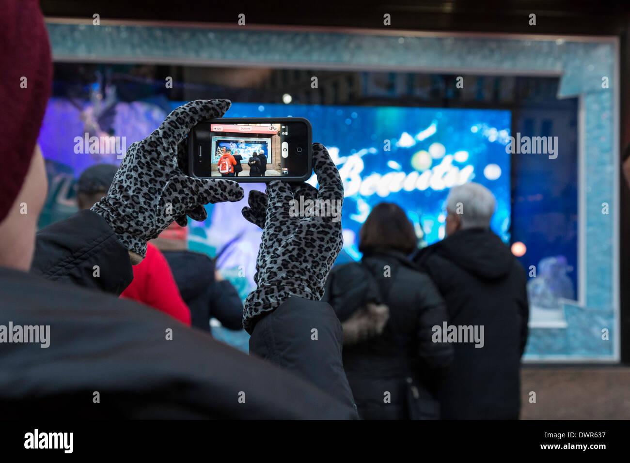 Femme à l'aide d'un téléphone cellulaire de Windows, Noël, du grand magasin Macy's Herald Square, New York, USA, Banque D'Images