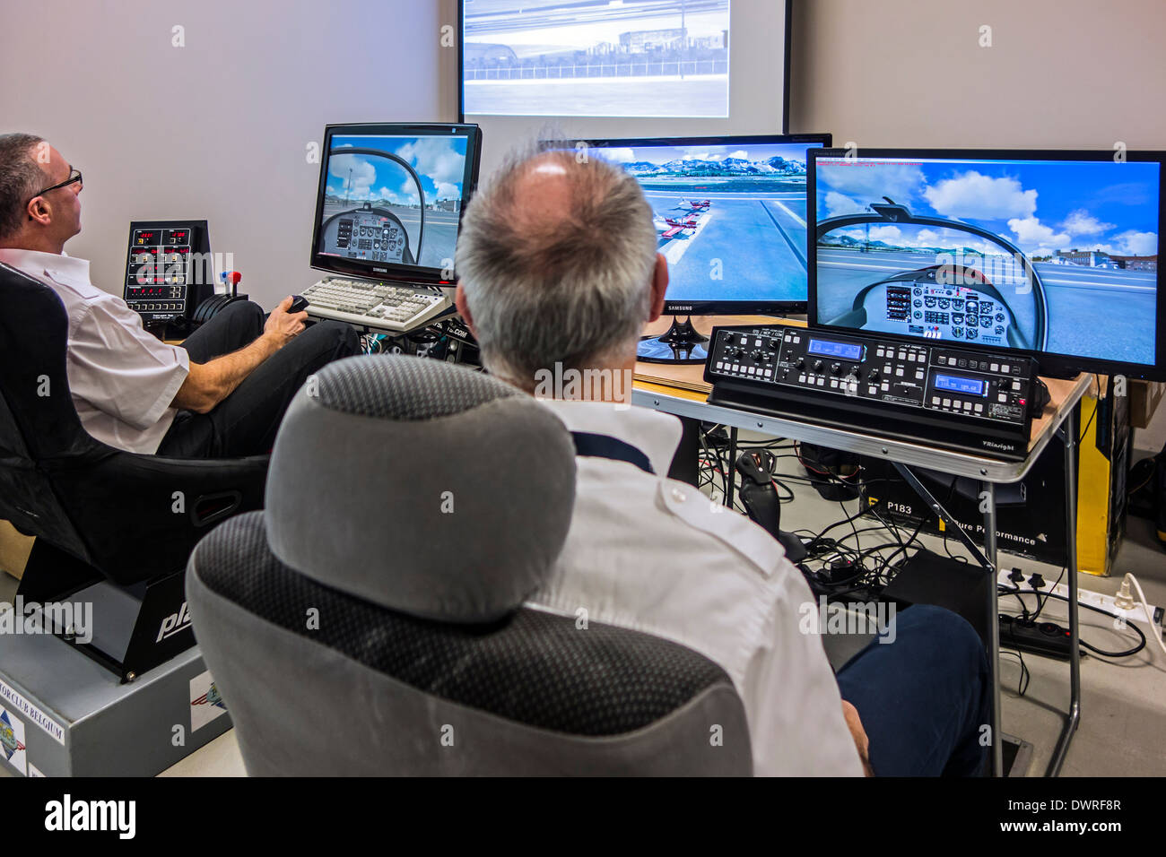 Deux hommes naviguant dans les avions virtuel simulateur de vol amateur sur des ordinateurs personnels Banque D'Images