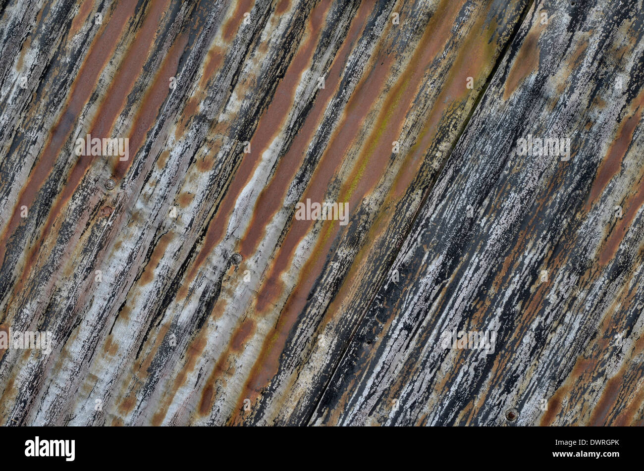 Texture abstraite de métal rouillé de tôle d'acier déchirée.La paroi latérale en tôle galvanisée d'un hangar abandonné a disparu avec le temps. Banque D'Images