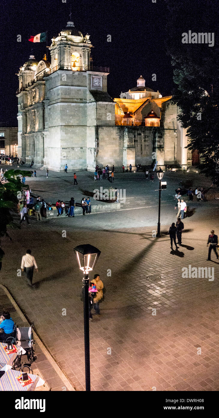 Scène de nuit à la recherche sur le Zocalo avec vue sur Cathédrale illuminée & plaza avec enfants jouant people socializing Oaxaca Banque D'Images