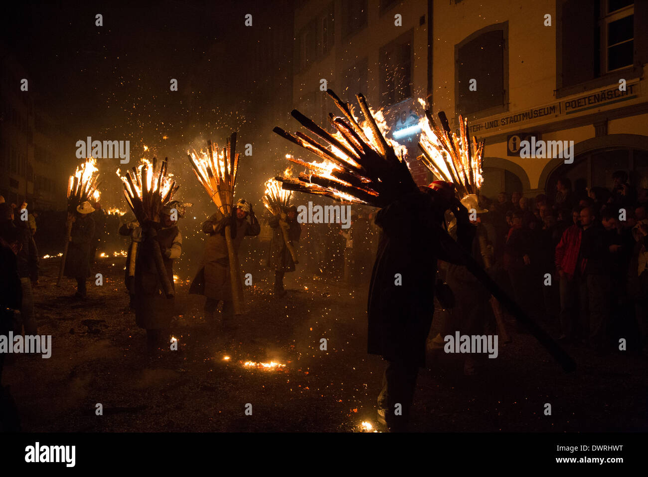 Les hommes d'un Photgraph marche autour avec balai en feu à l'incendie traditionnels bâtons 'parade' Chienbaese pour carnaval à Liestal. Banque D'Images
