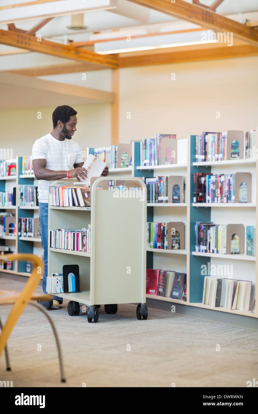 Bibliothécaire à la bibliothèque de livres en organisant trolley Banque D'Images