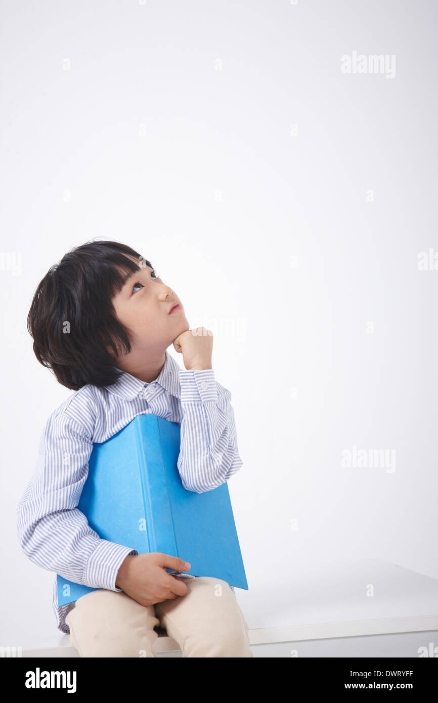 Un enfant assis sur une table de penser Banque D'Images