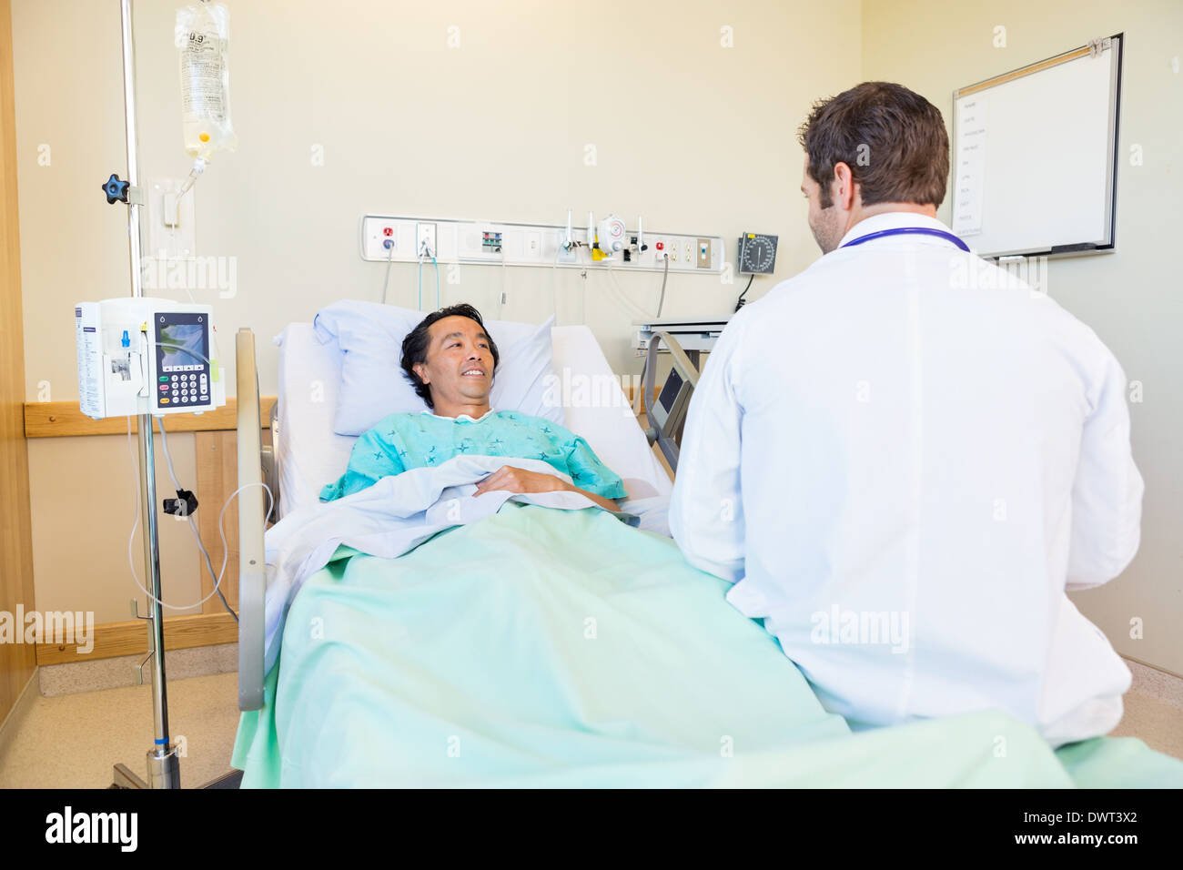 Patient médecin mature tout en se trouvant sur lit d'hôpital Banque D'Images