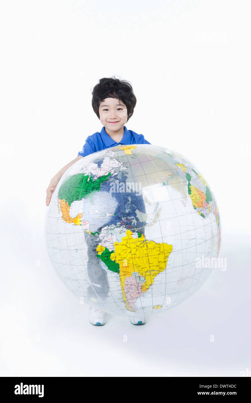 Un enfant tenant un grand globe rempli d'air Banque D'Images
