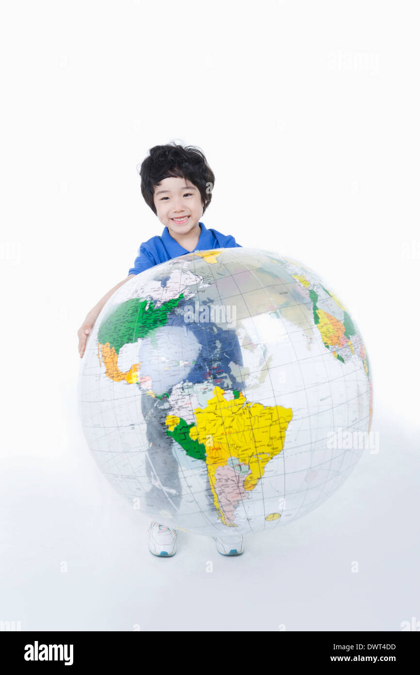 Un enfant tenant un grand globe rempli d'air Banque D'Images