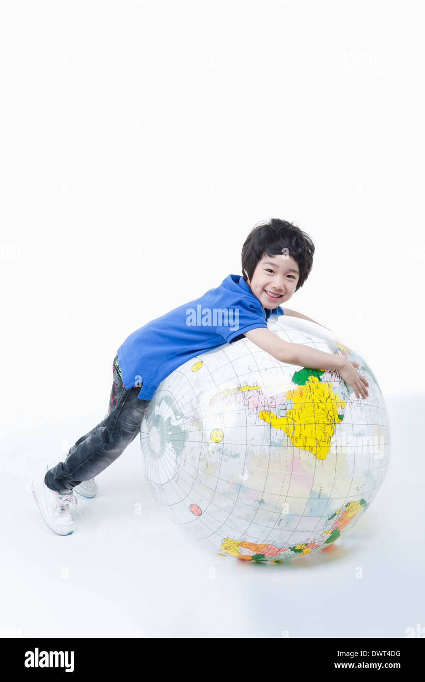 Un enfant jouant avec un grand globe rempli d'air Banque D'Images