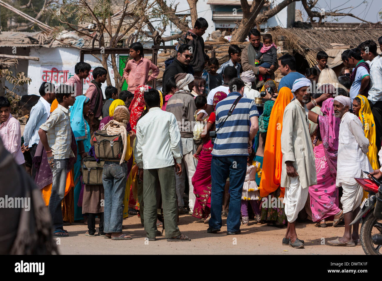Abnaheri, Rajasthan, Inde. Village foule rassemblée autour de deux touristes. Banque D'Images