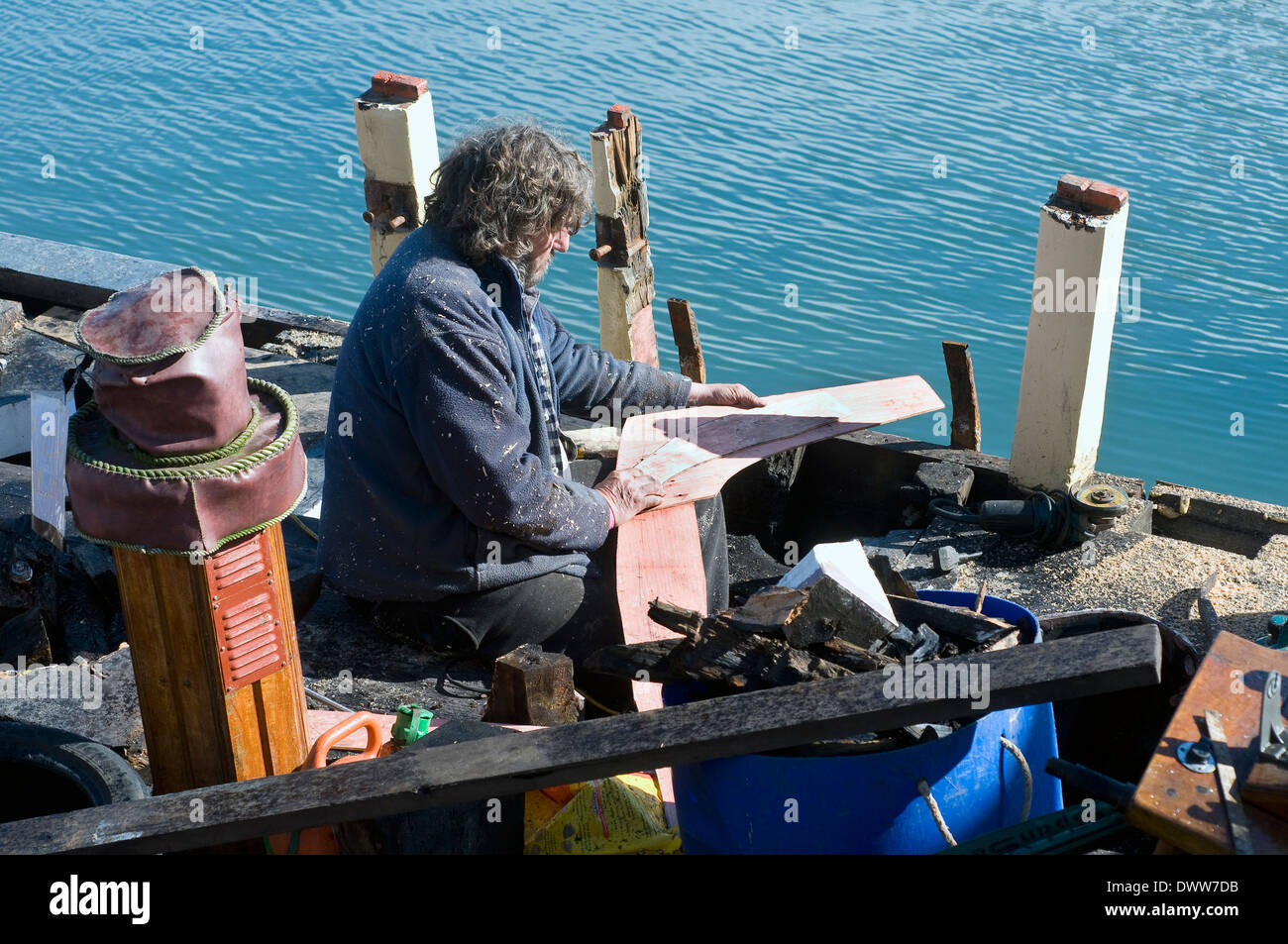 Carpenter en coque de vieux bateau Brixham Devon,voile, profiter, pêche, fixer, heureux, passe-temps, d'emploi, l'entretien, l'homme, vieux, la peinture, repairin Banque D'Images