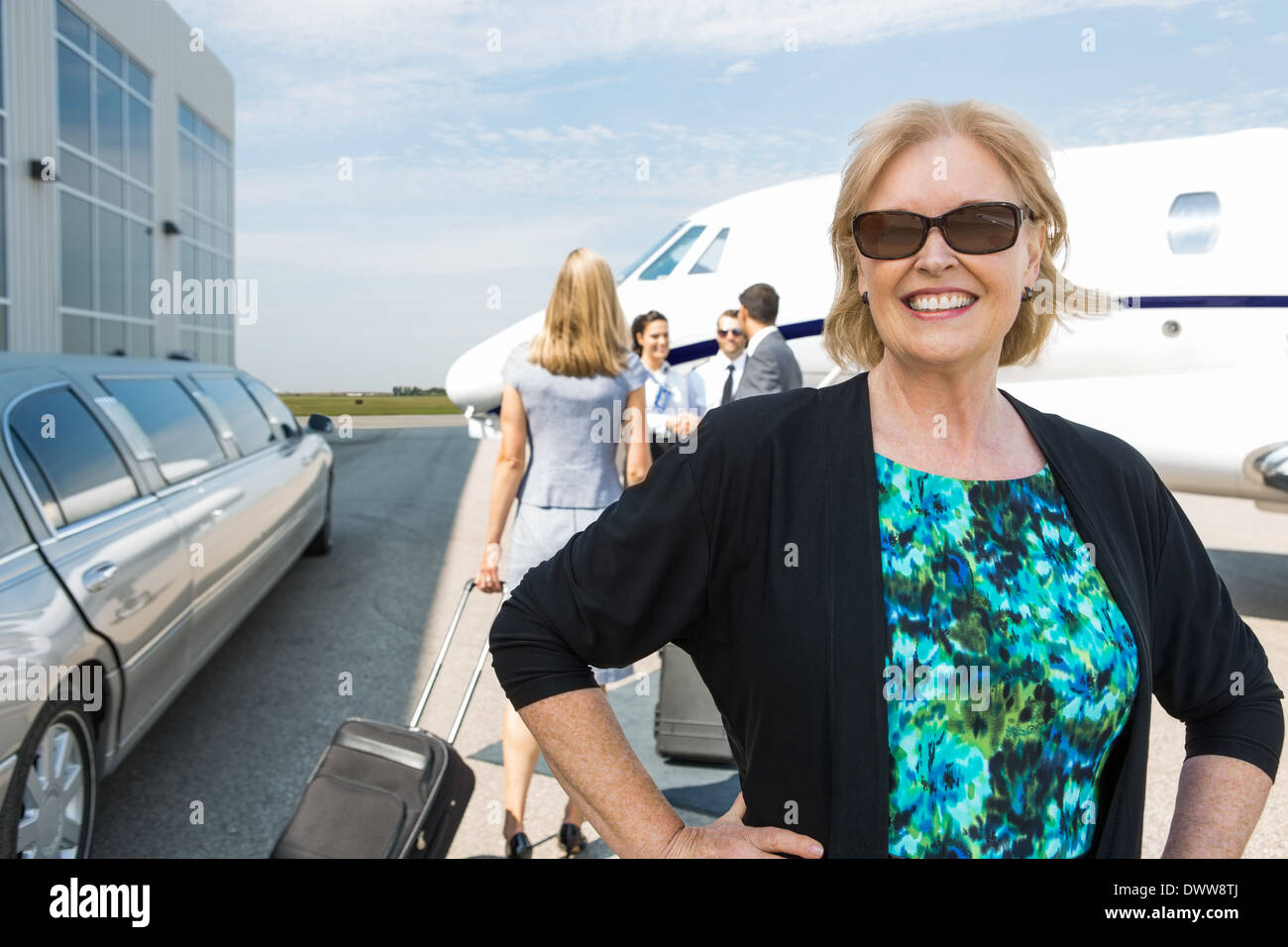 Happy businesswoman contre private jet Banque D'Images