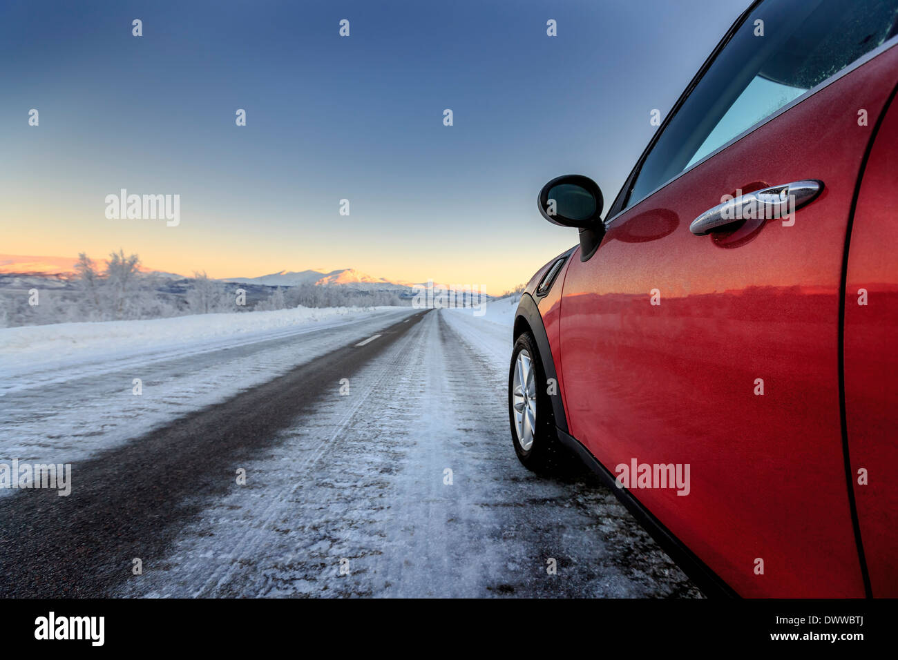 Côté de voiture rouge sur route, Laponie, Suède Banque D'Images