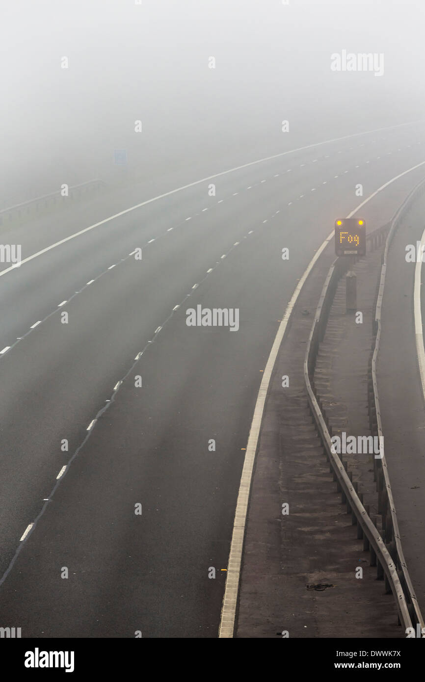 UK d'autoroute avec panneau d'avertissement de brouillard dans le brouillard ou brouillard Banque D'Images