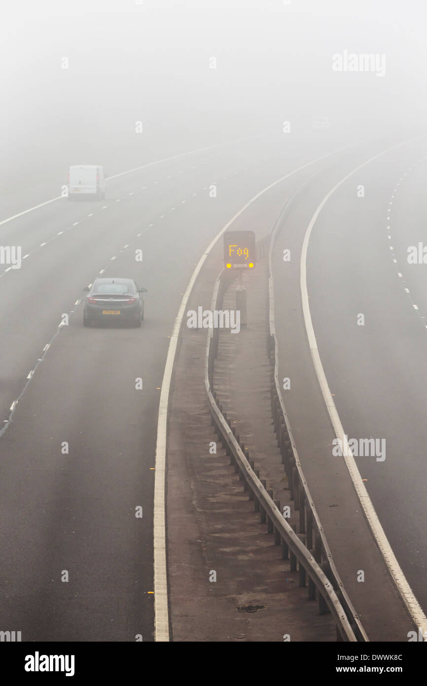 UK d'autoroute avec panneau d'avertissement de brouillard dans le brouillard ou brouillard Banque D'Images