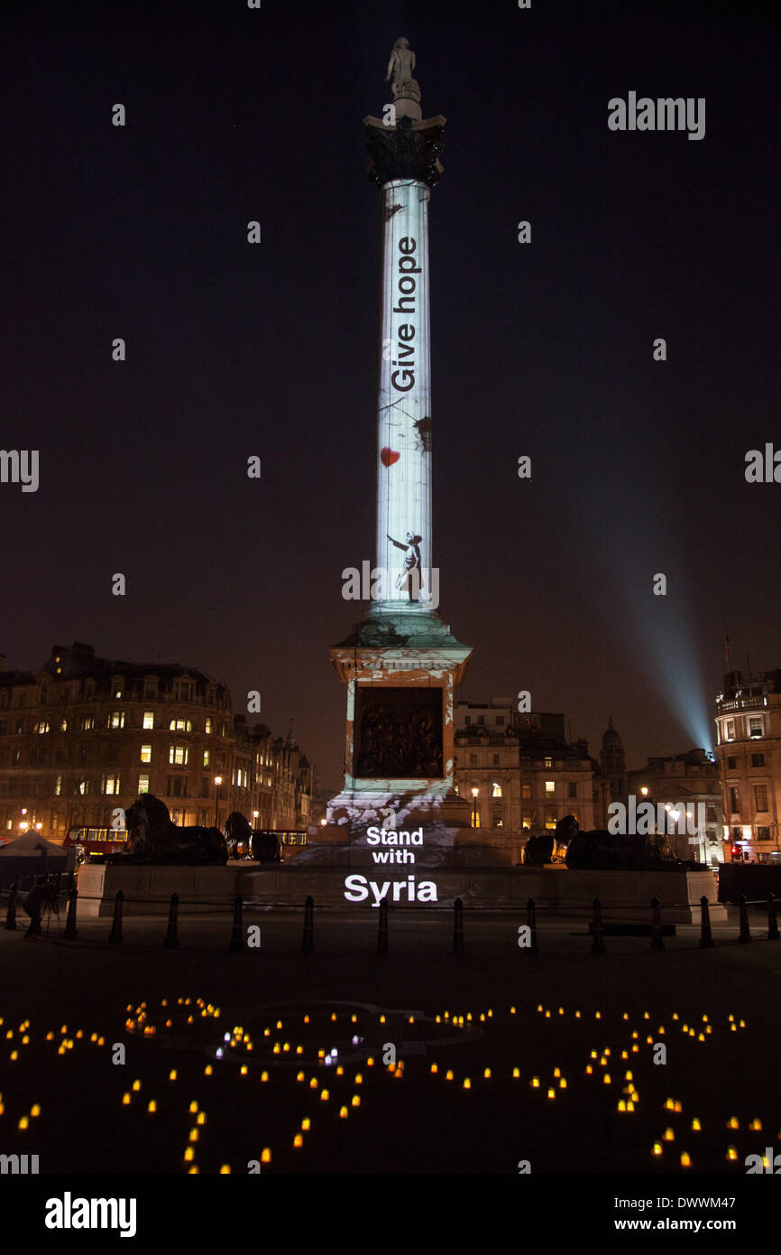 Londres, Royaume-Uni. 13Th Mar, 2014. La colonne Nelson à Trafalgar Square à Londres est éclairé avec art par Banksy dans le cadre d'une veillée à pour lancer la campagne Stand avec la Syrie. La campagne vise à mettre en évidence le fait que la guerre en Syrie est en cours depuis trois ans le 15 mars et que la guerre doit cesser. Credit : Kristian Birsfelden/Alamy Live News Banque D'Images