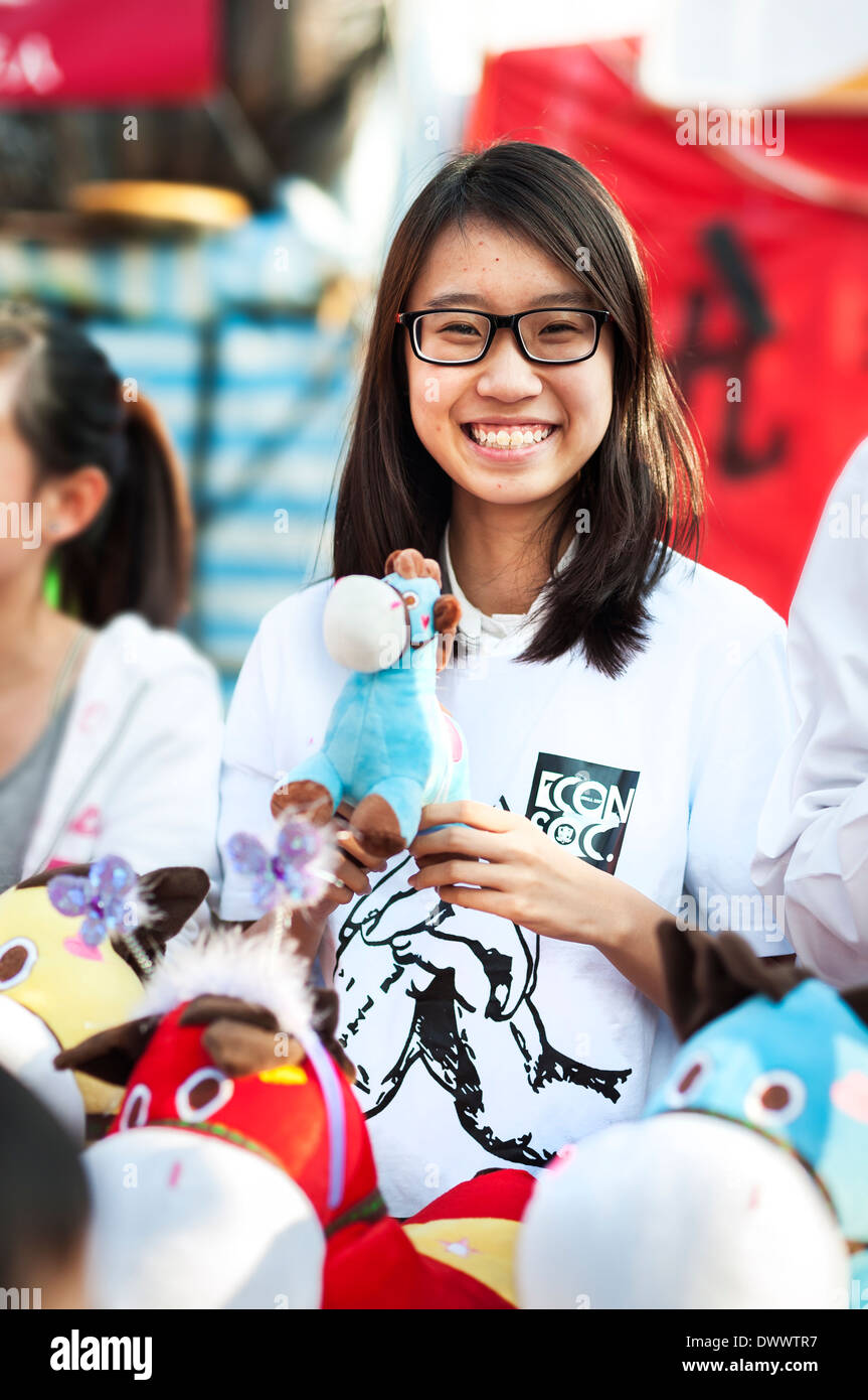 Young Girl holding a toy horse à l'assemblée annuelle du marché de l'an dans le parc Victoria, Hong Kong Banque D'Images
