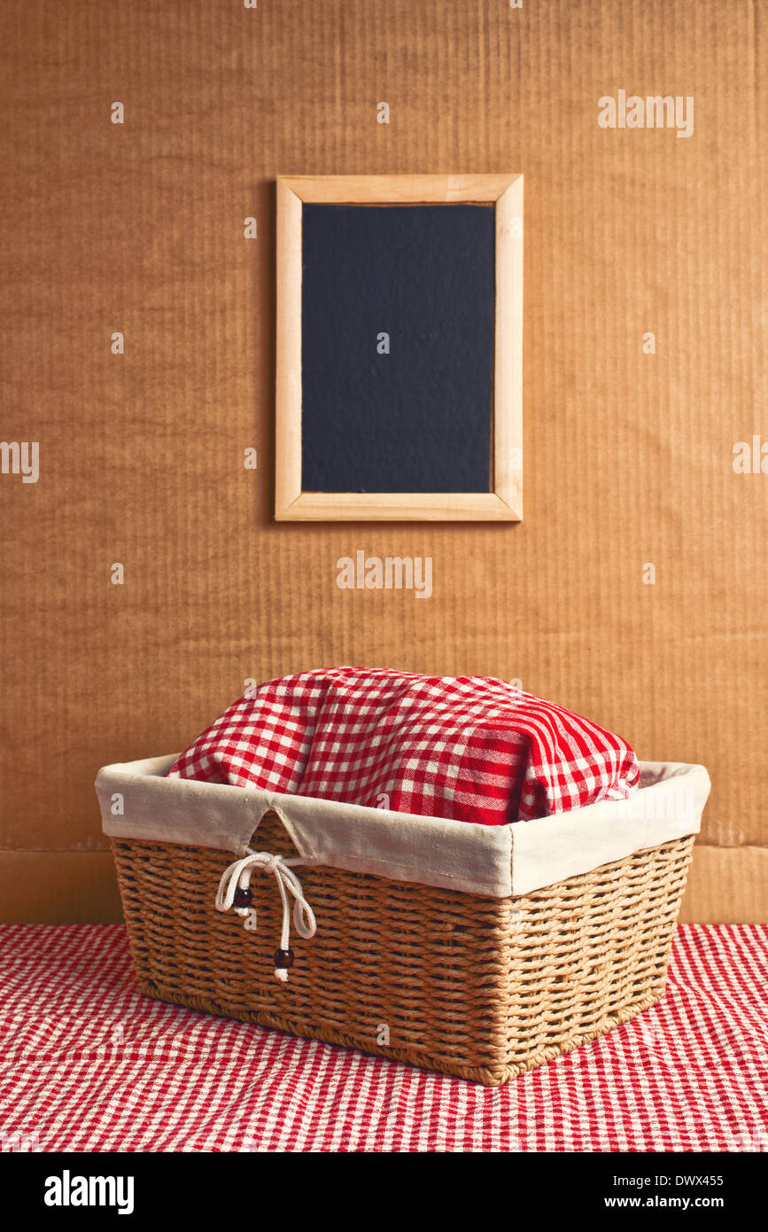 Pain dans panier en osier recouvert de rag sur table de cuisine with copy space Banque D'Images