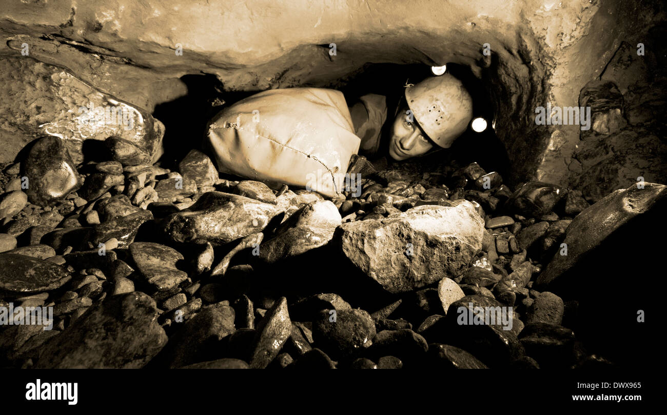 Un jeune spéléologue explore un passage souterrain dans la grotte, Dwr mcg vallée de Swansea, Brecon Beacons, Galles, Royaume-Uni Banque D'Images