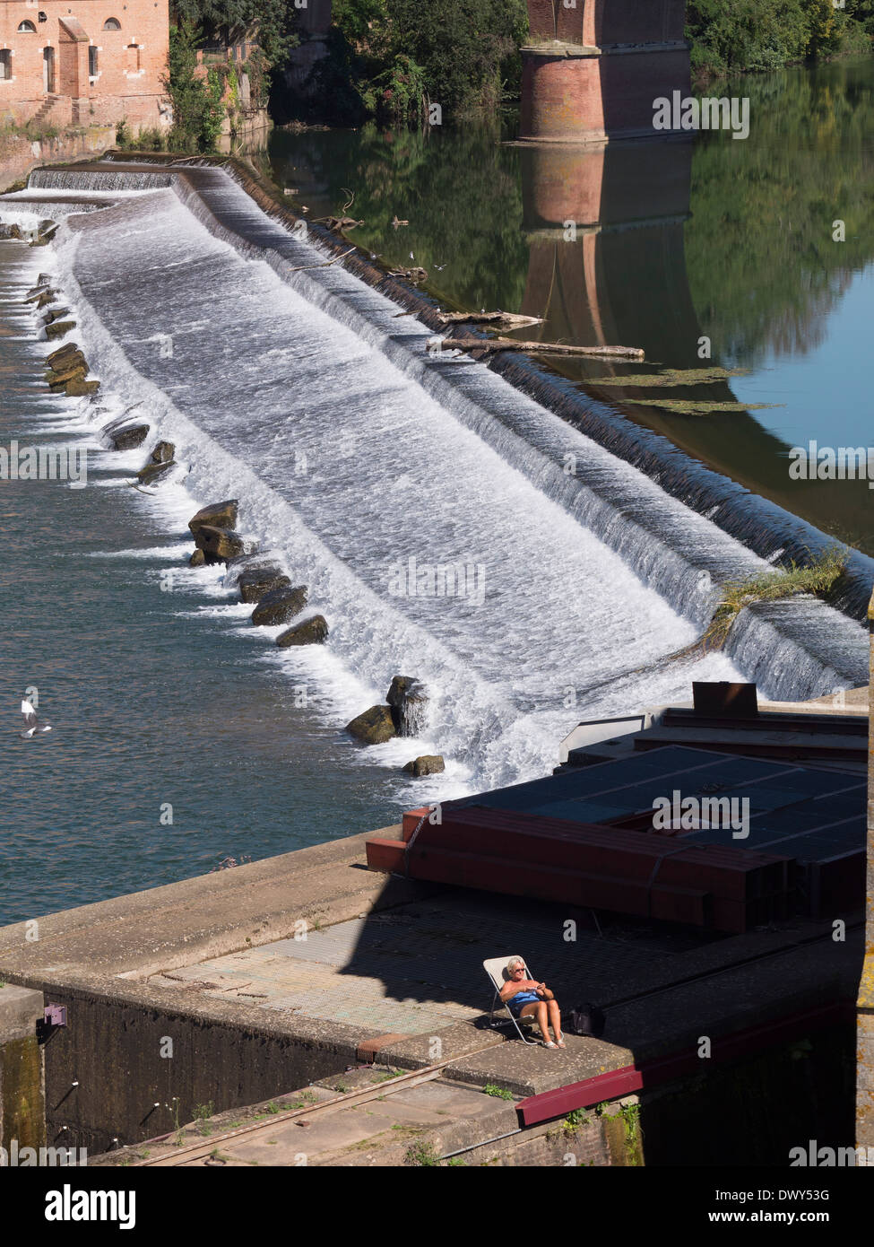 Une femme de soleil à côté d'un barrage sur la rivière Tarn à Albi, Languedoc, France, vue depuis le Pont Vieux Banque D'Images