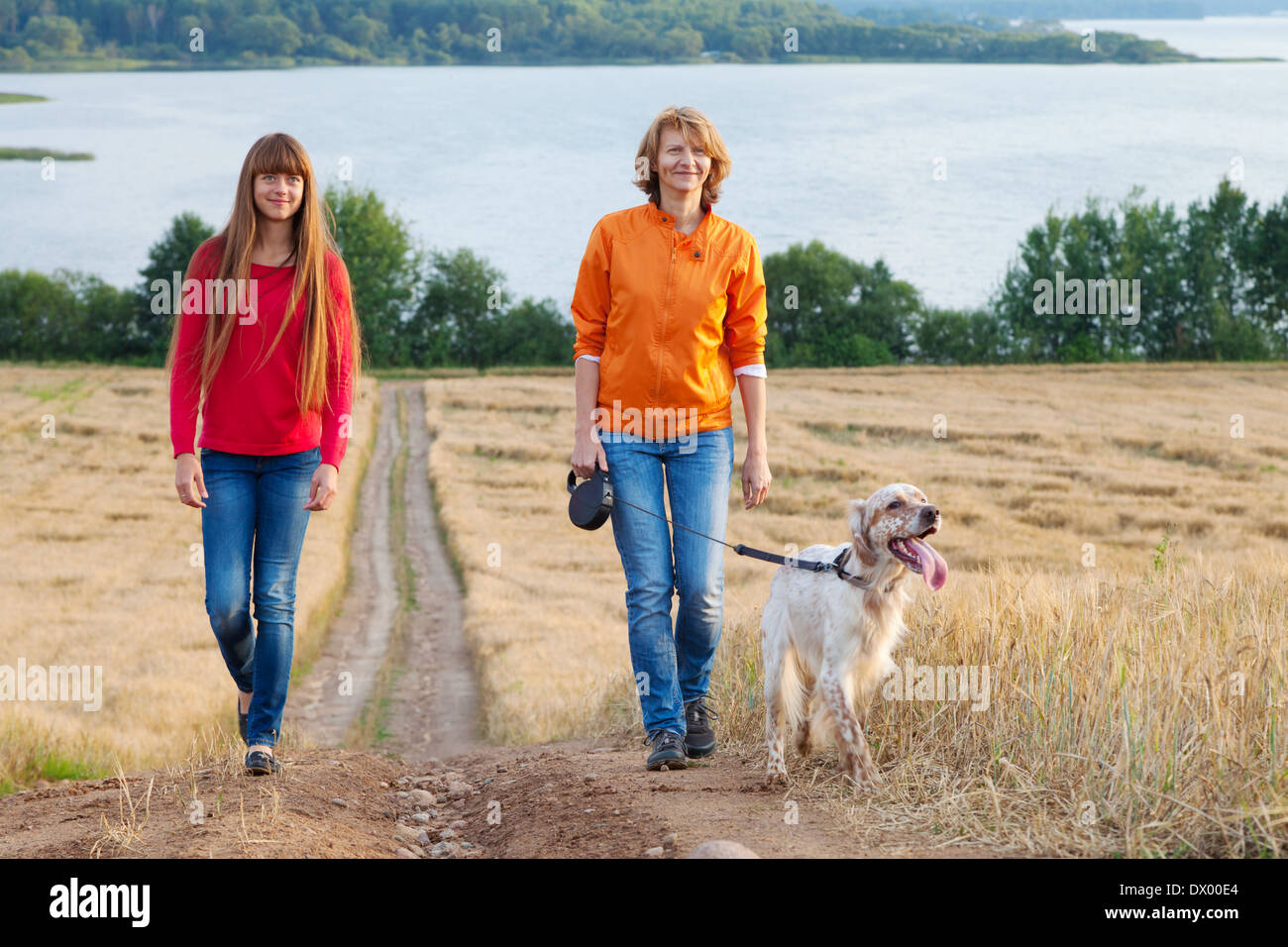 Mère et sa fille avec chien marcher près du lac Banque D'Images