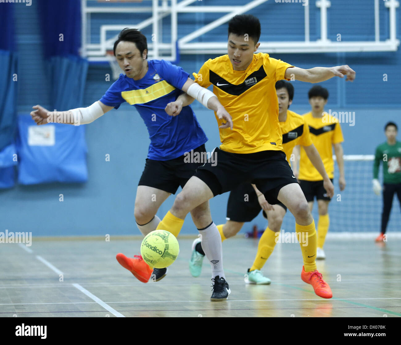 Cambridge, UK. Mar 15, 2014. Wang Xianzhi (R) de l'Université de Sheffield La société de Hong Kong(SHKS) s'acharne pour l'équipe de la balle au cours de l'UK Chinese cinq-A-side football intérieur University Cup 2014 à l'Université de Cambridge Sports Centre à Cambridge, en Grande-Bretagne, le 15 mars 2014. SHKS Team a demandé le titre en battant Team Chinese Students and Scholars Association à Cambridge (CSSA) avec 4-1 en finale. Credit : Wang Lili/Xinhua/Alamy Live News Banque D'Images