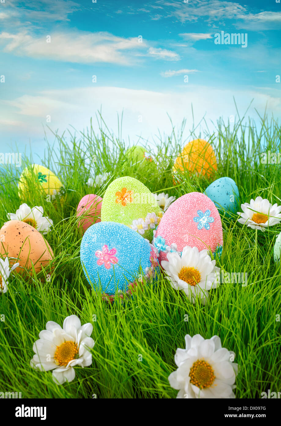 Oeufs de Pâques décorés dans l'herbe sur fond de ciel bleu Banque D'Images