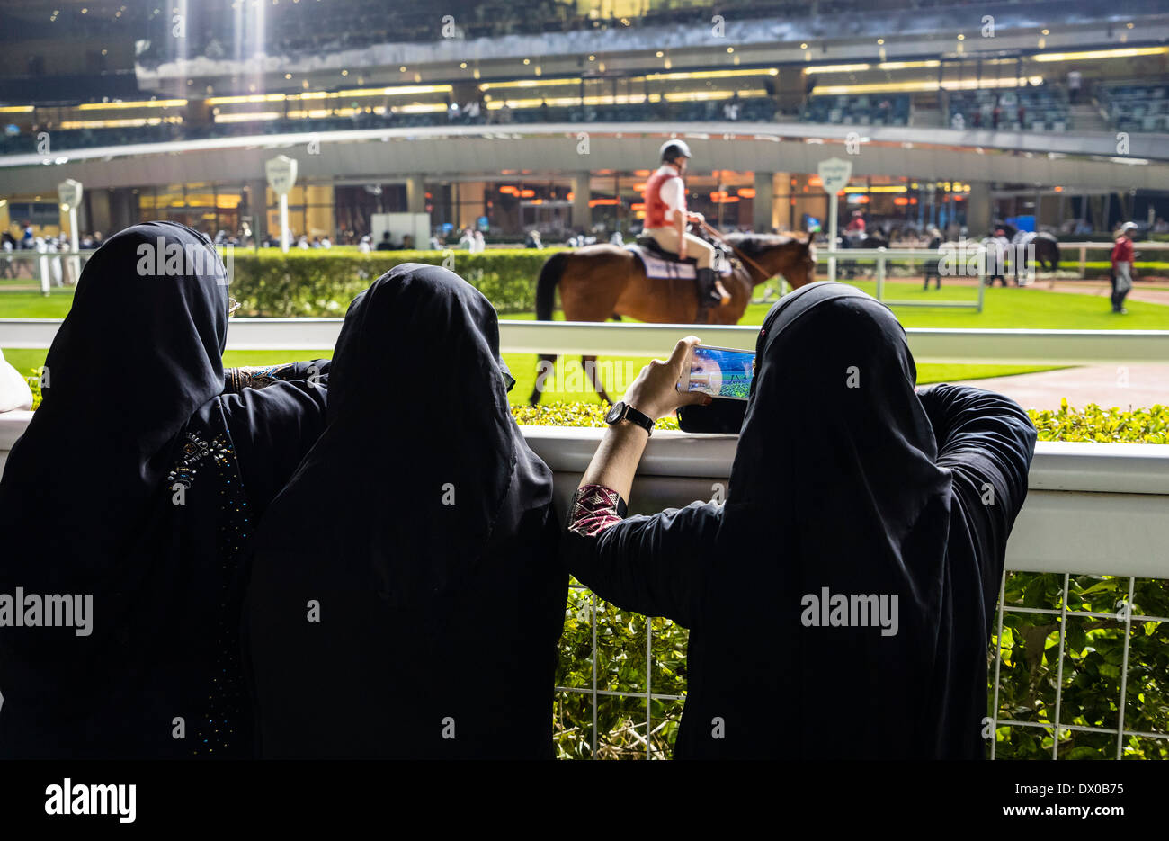 Les femmes à la recherche de Local Emirati parade de chevaux dans la bague  à l'hippodrome de Meydan Al nuit à Dubaï Émirats Arabes Unis Photo Stock -  Alamy