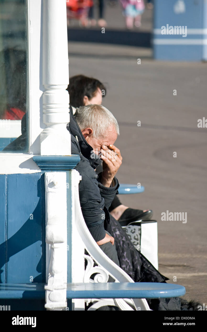 Les gens assis dans un abri en bord de mer sur l'Esplanade, Weymouth, Dorset. Banque D'Images