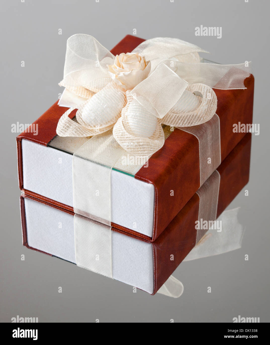 La boîte cadeau avec un couvercle marron est enveloppé par une bande beige avec un archet. Banque D'Images