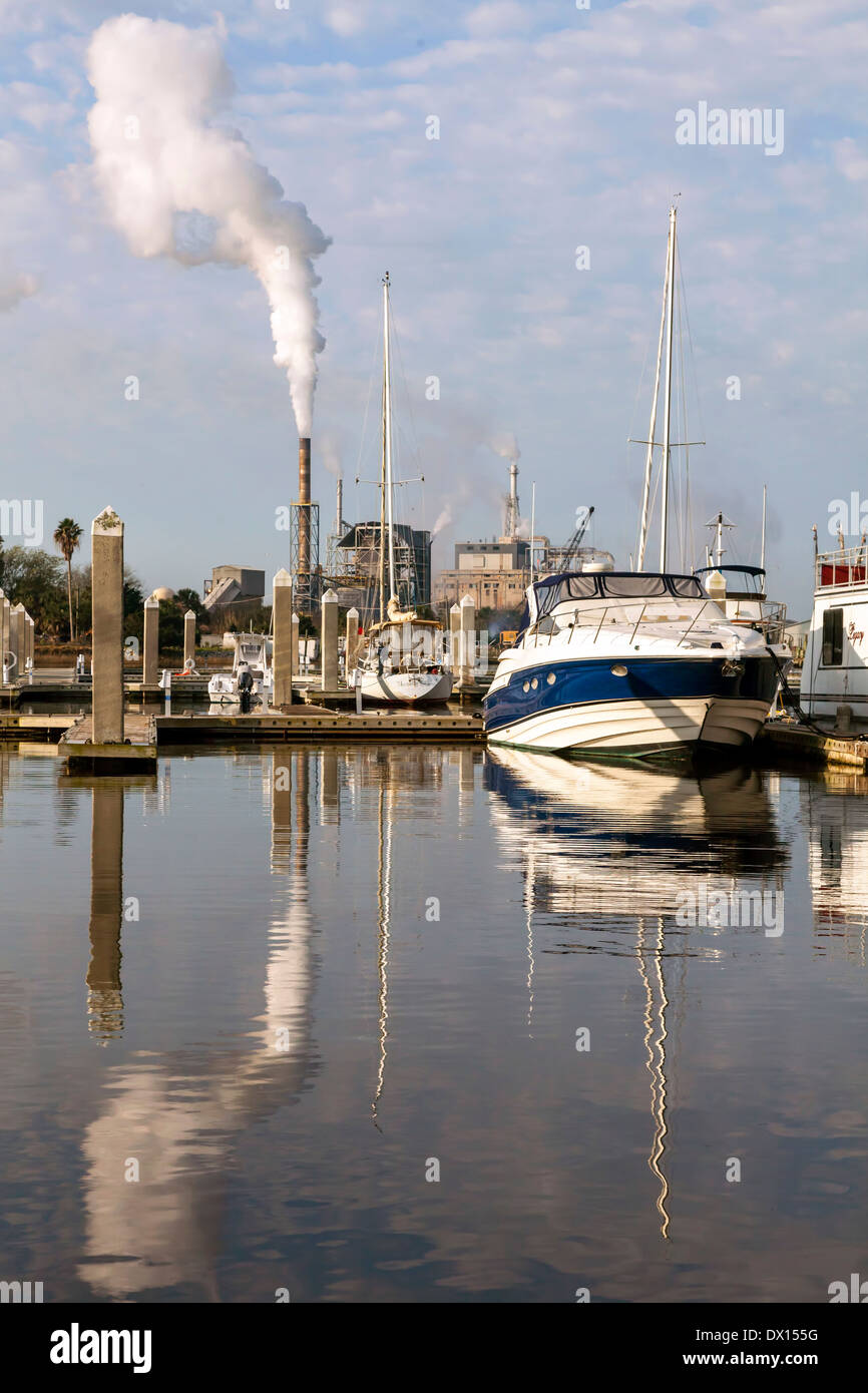 Bateaux à quai dans le port de Baltimore et une centrale électrique avec cheminées visible au-delà, aux États-Unis. Banque D'Images