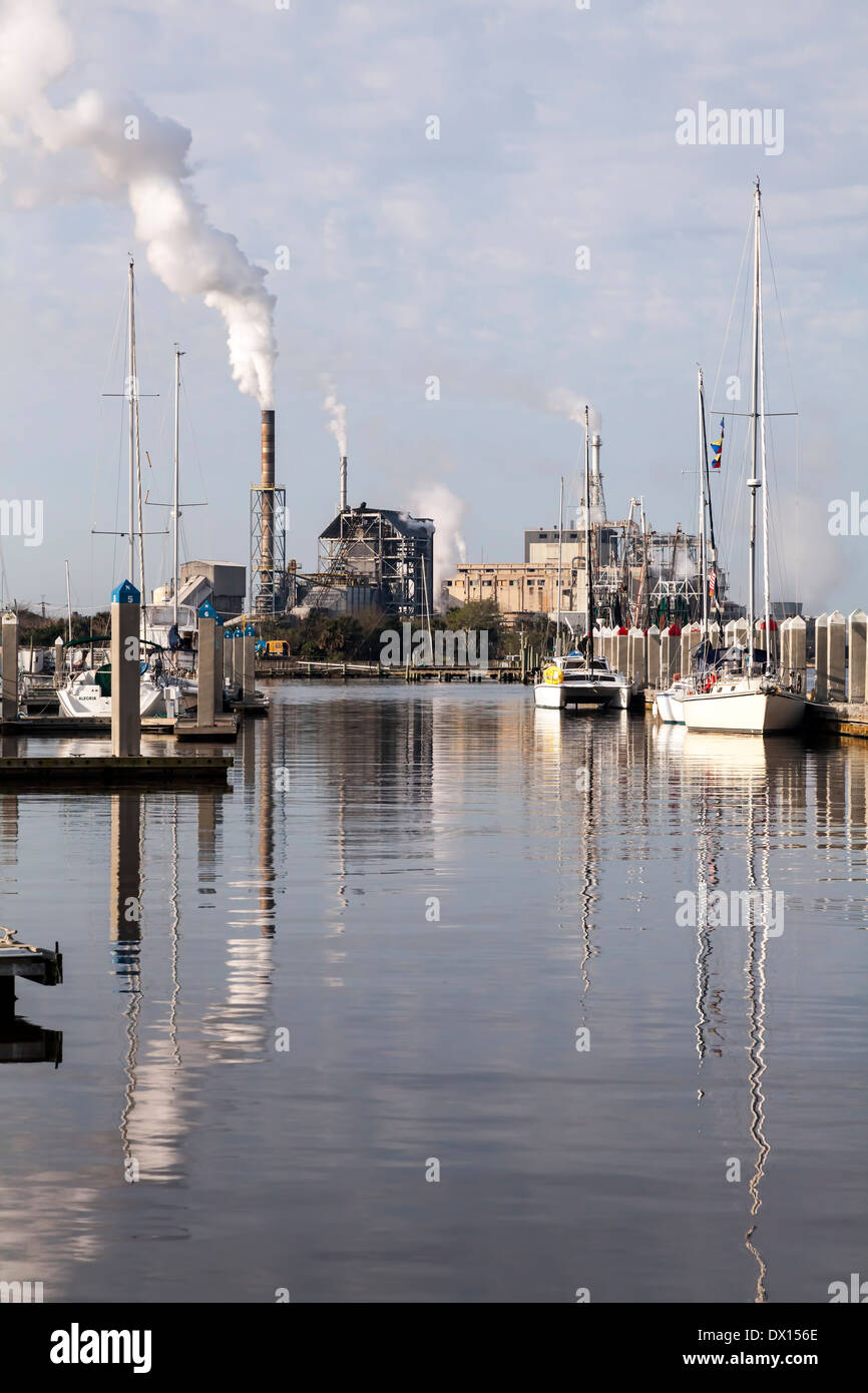 Voiliers à quai dans le port de Baltimore et une centrale électrique avec cheminées visible au-delà, aux États-Unis. Banque D'Images