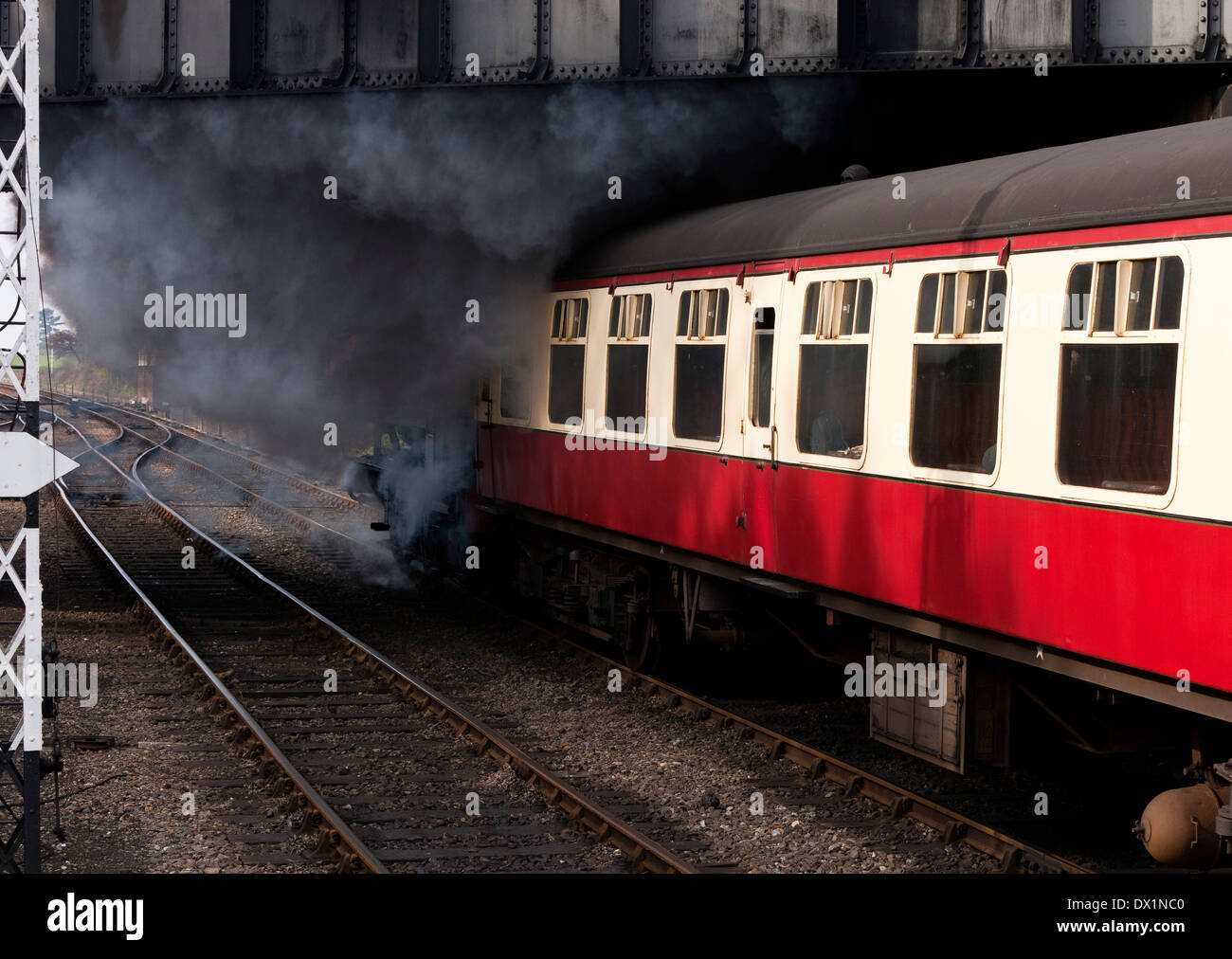 Train à vapeur sous un pont routier de quitter la station de Sheringham à Norfolk, Angleterre Banque D'Images