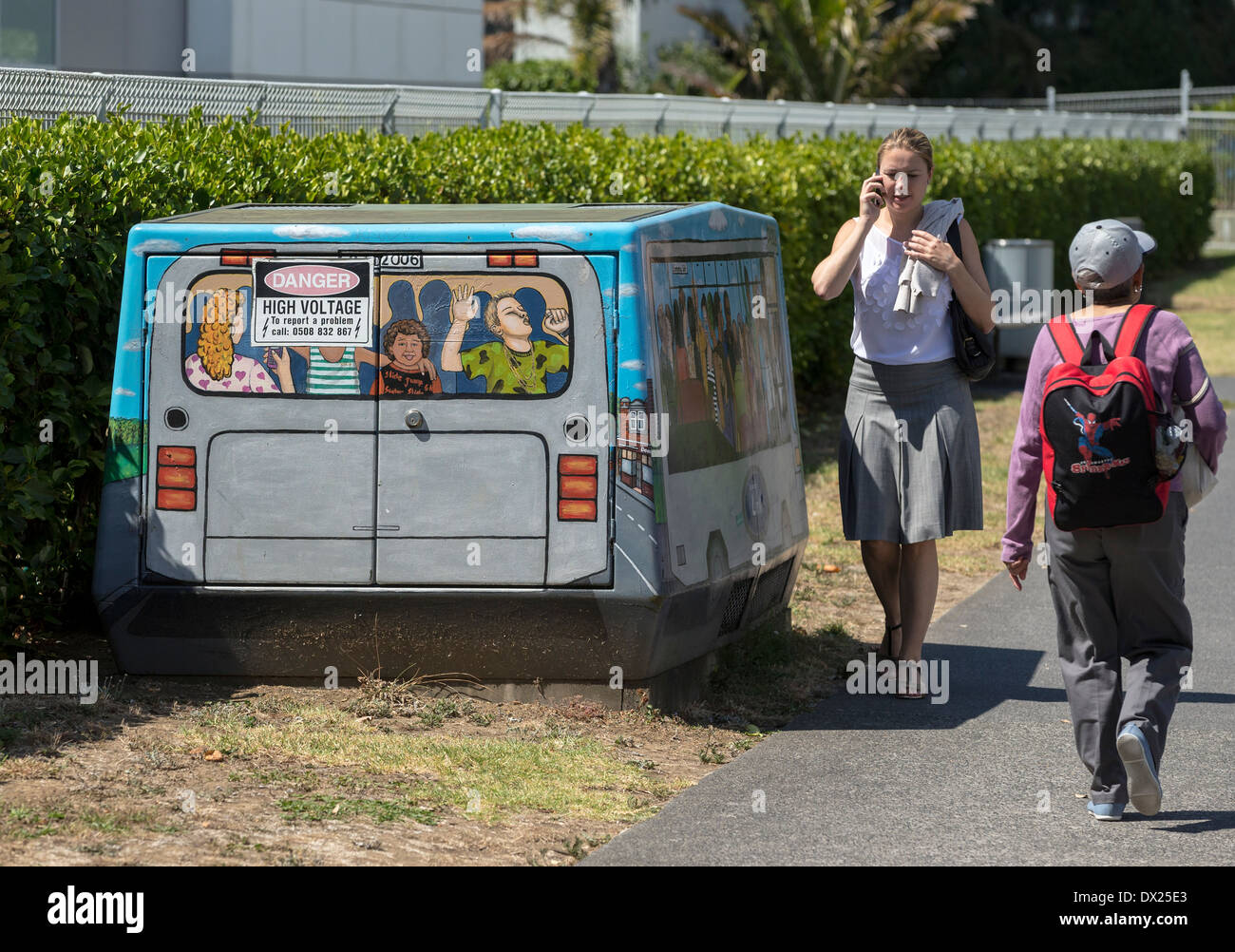 Les piétons passant une boîte de jonction de télécommunications à Auckland, Nouvelle-Zélande, peint pour ressembler à un bus Banque D'Images