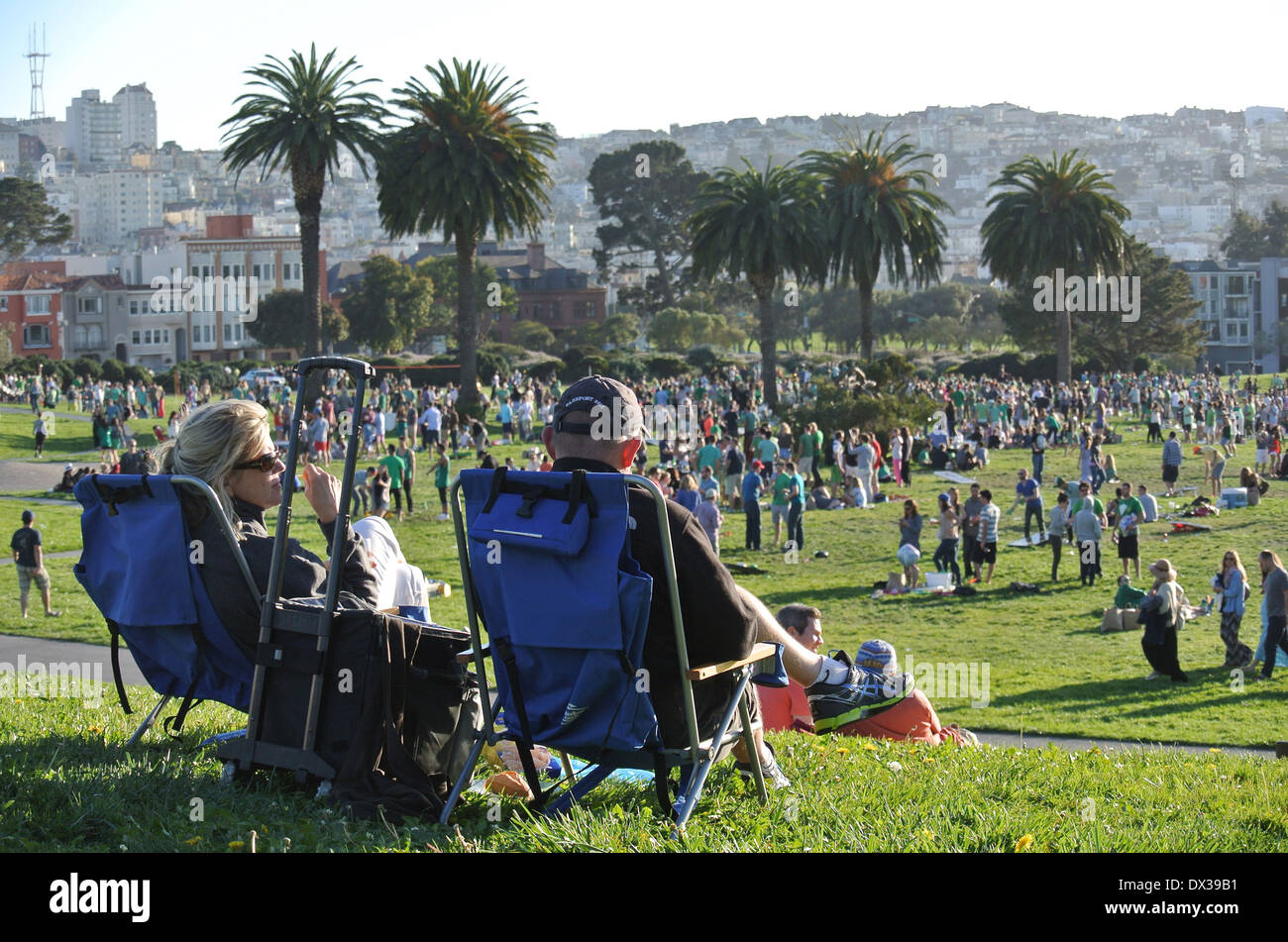 Couple assis dans des chaises de jardin et regarder une foule de personnes partie à San Francisco Banque D'Images