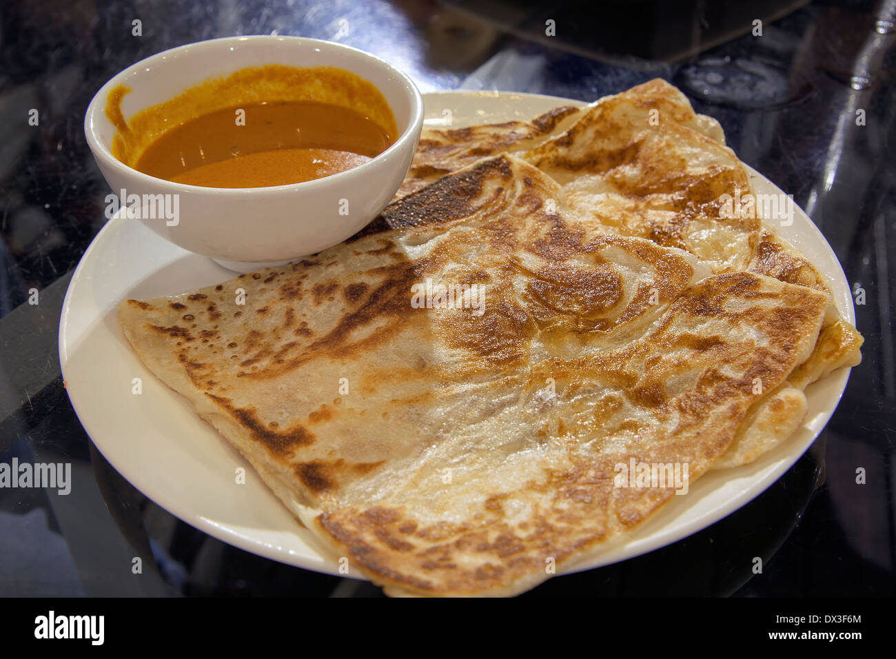 Roti Prata avec bol de sauce curry closeup Banque D'Images