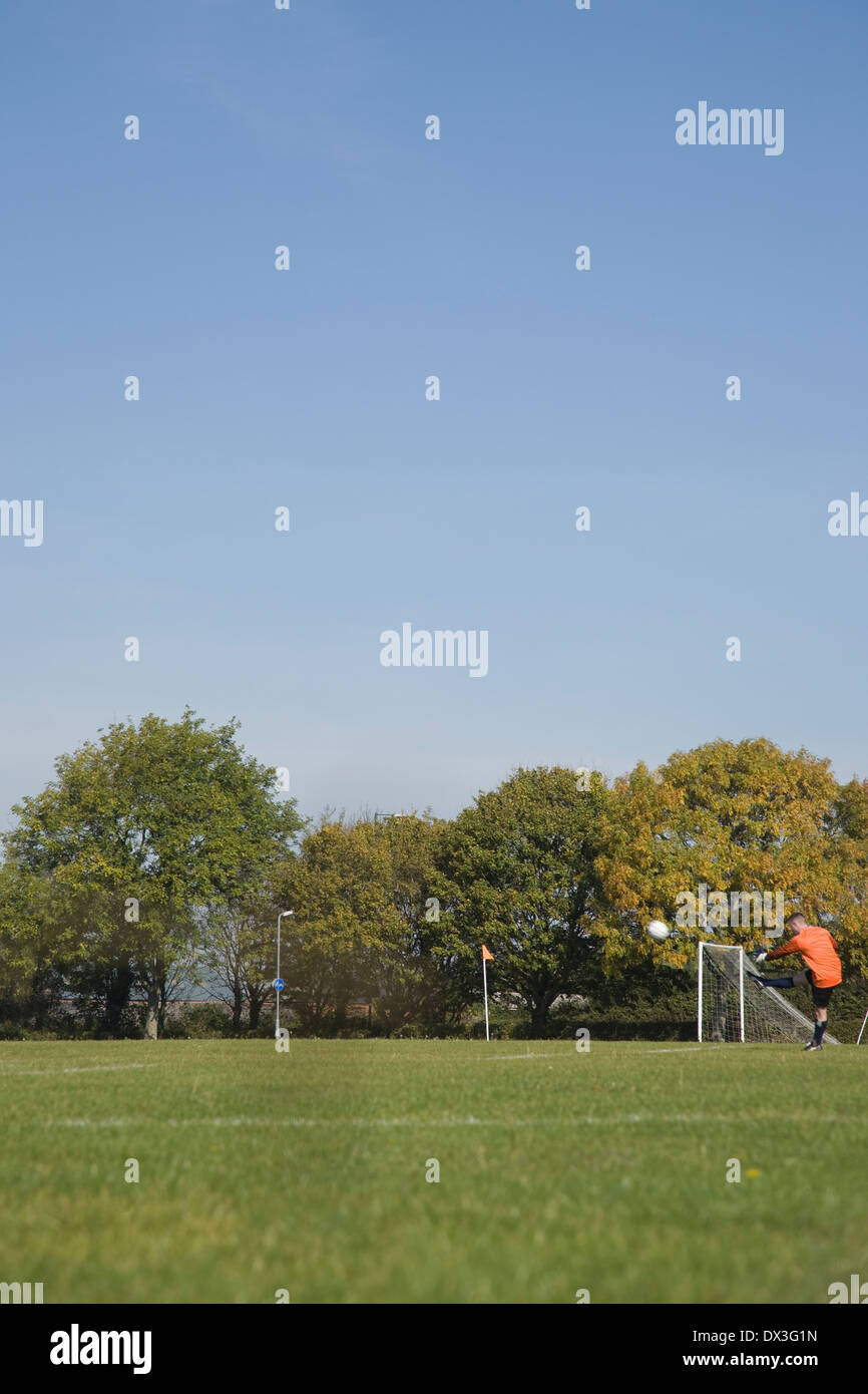 Un gardien de but coups la balle à un match de la ligue de football amateur Banque D'Images