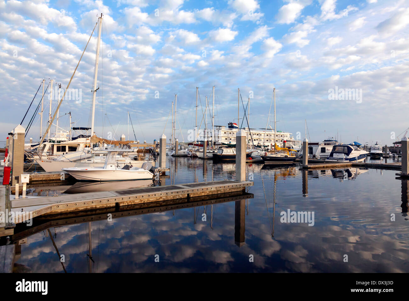 Les nuages blancs moelleux (Altocumulus floccus) reflète dans l'eau sombre de la Fernandina Beach port et quais, USA. Banque D'Images